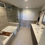 Custom bathroom remodel with curb less walk-in shower, floating vanity, tub deck, and niches by Eckert Renovations in Broomfield Colorado