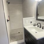 Large custom tiled shower with modern fixtures and clean layout by Eckert Renovations in Arvada Colorado