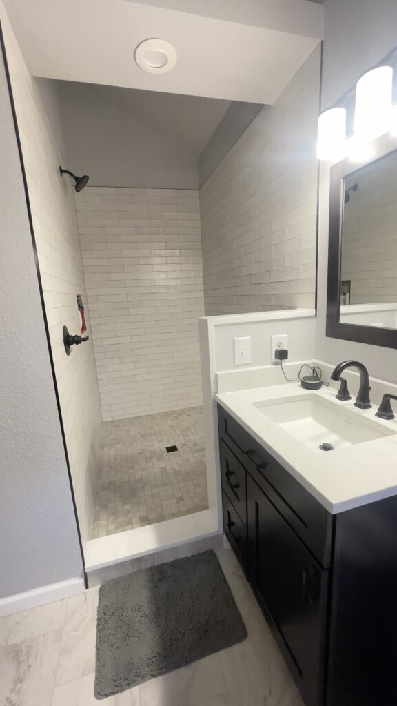 Large custom tiled shower with modern fixtures and clean layout by Eckert Renovations in Arvada Colorado