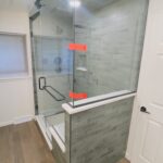 Custom steam shower with large format tile, built-in bench, and glass enclosure by Eckert Renovations in Lafayette Colorado