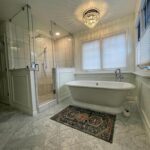 Custom bathroom remodel with marble tile, freestanding tub, and heated floors by Eckert Renovations in Westminster Colorado